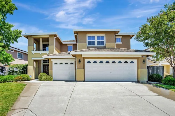 a view of a white house with a large tree