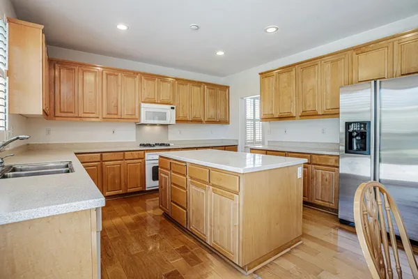 a view of a dining room and livingroom with furniture wooden floor a chandelier