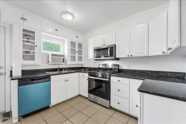a kitchen with granite countertop white cabinets and white stainless steel appliances