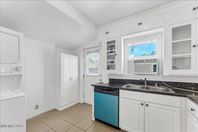a kitchen with granite countertop a sink and a white cabinets