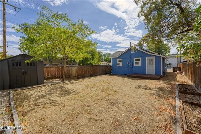 a house view with wooden fence and a trees