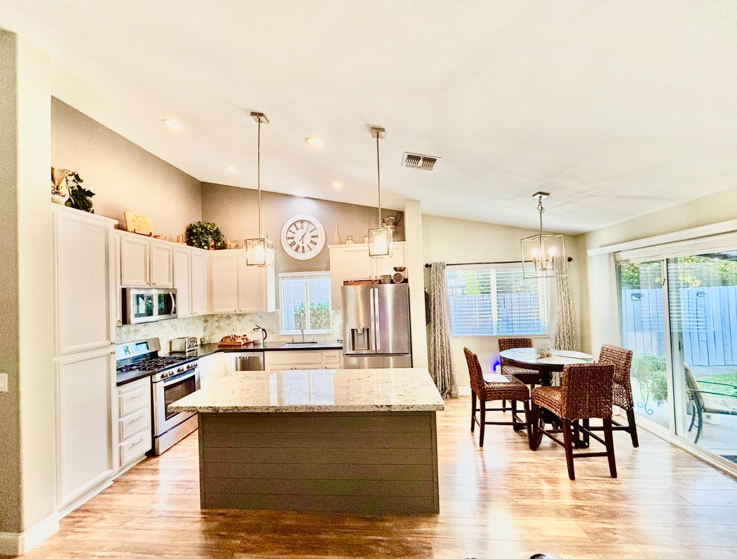111 McCurry Street Wheatland, CA 95692 - Photo 8 of 55 a kitchen with stainless steel appliances kitchen island granite countertop a table chairs and a refrigerator
