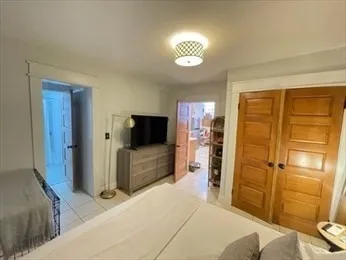 a bedroom with a bed and a flat tv screen on dresser
