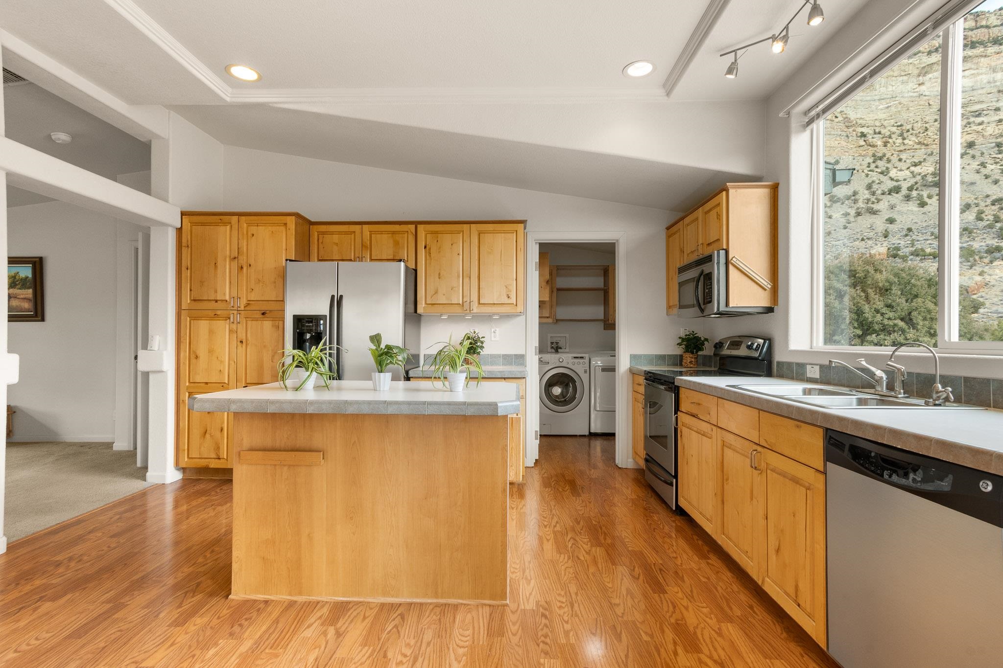 3984 Rapid Creek Road Palisade, CO 81526 - Photo 10 of 30 a kitchen with stainless steel appliances granite countertop a stove a sink dishwasher and a refrigerator with wooden floor