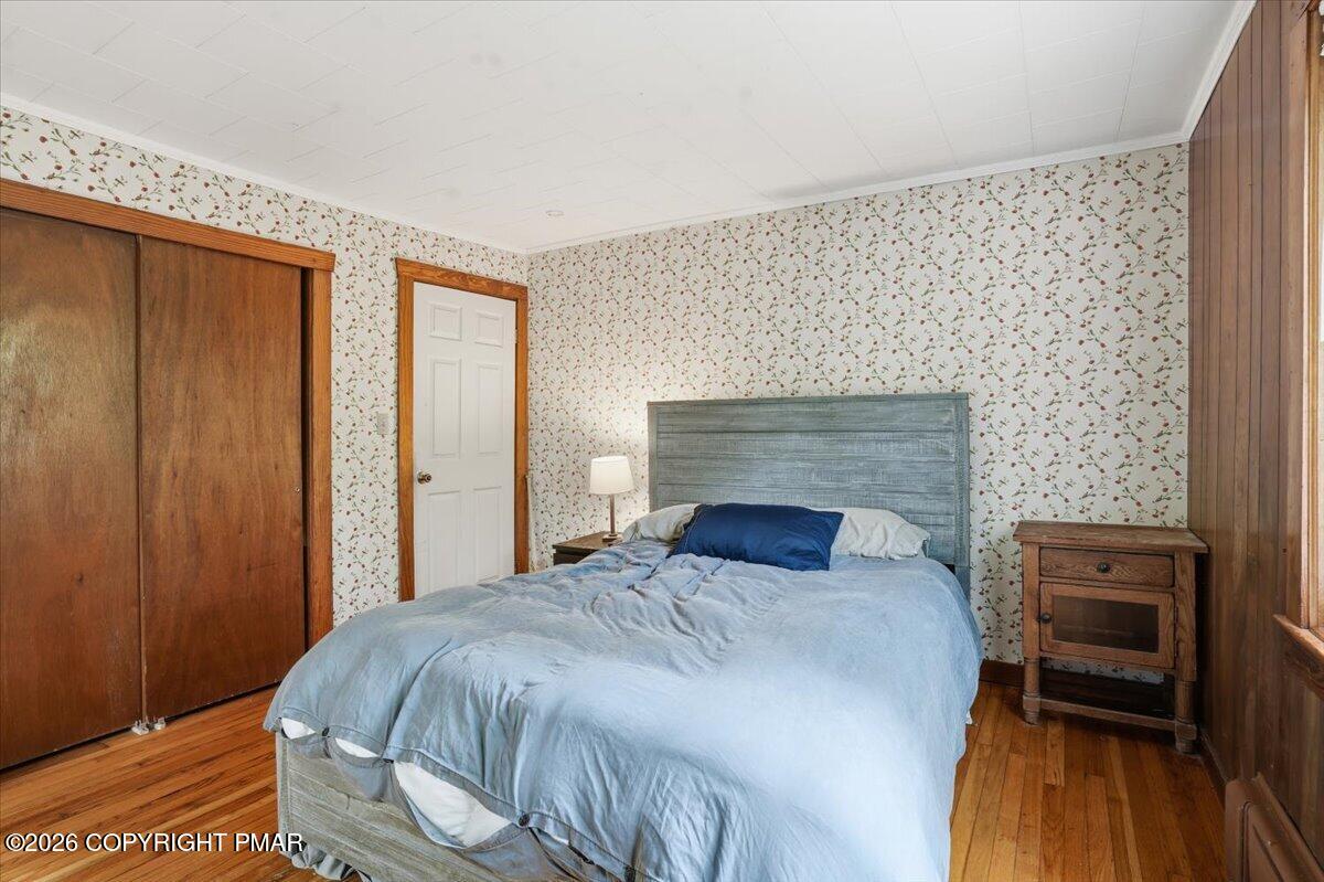 232 Garrity Road Hawley, PA 18428 - Photo 31 of 57 a bedroom with a bed and wooden floor