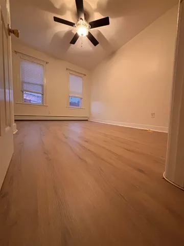 an empty room with windows and fan
