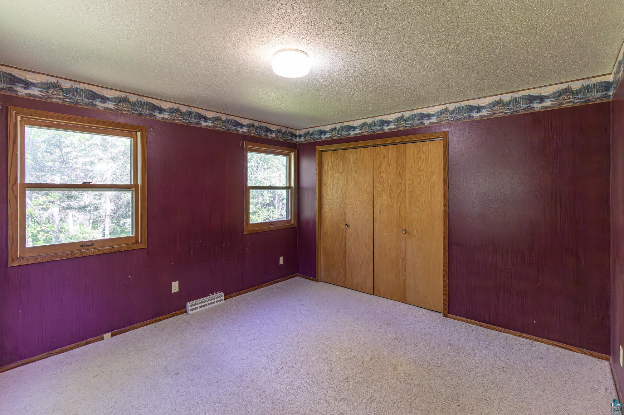 14687 North Country Road Ely, MN 55731 - Photo 13 of 44 Unfurnished bedroom featuring carpet, a closet, and a textured ceiling