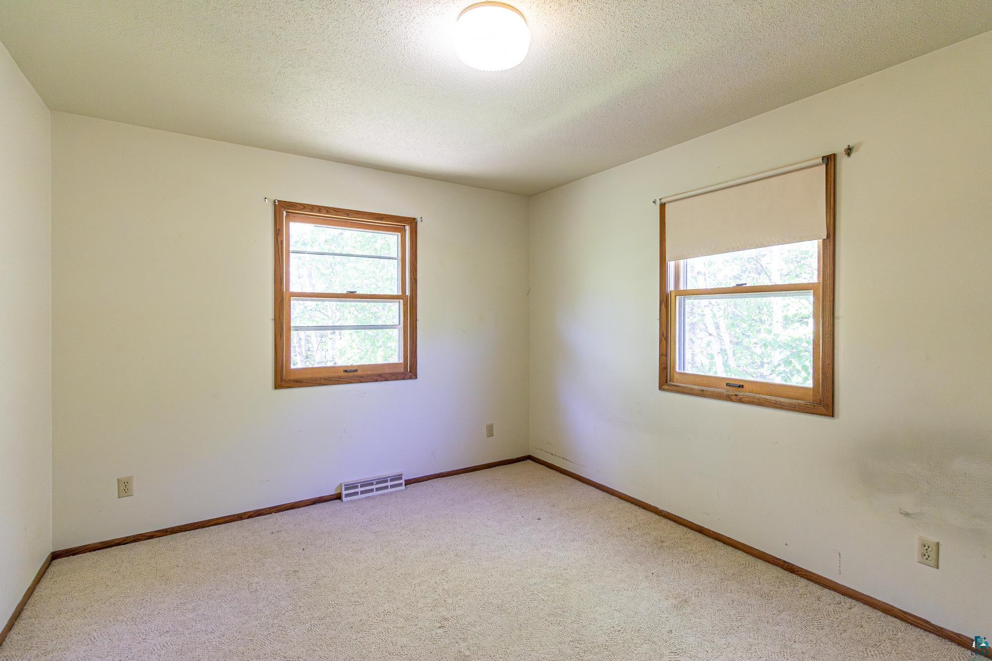 14687 North Country Road Ely, MN 55731 - Photo 21 of 44 Carpeted empty room featuring a textured ceiling and a wealth of natural light