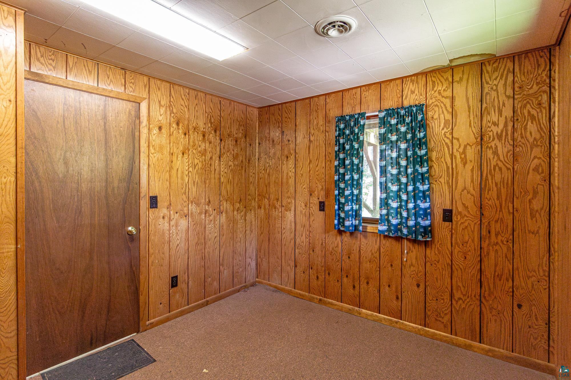 14687 North Country Road Ely, MN 55731 - Photo 23 of 44 Spare room featuring wooden walls and carpet flooring