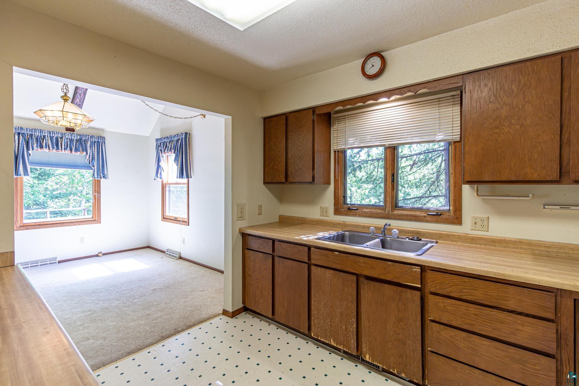 14687 North Country Road Ely, MN 55731 - Photo 6 of 44 Kitchen featuring hanging light fixtures, sink, and light carpet