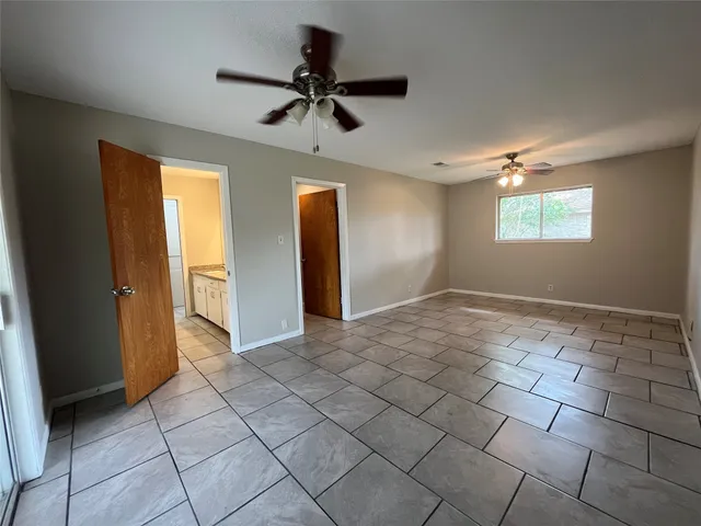a view of a livingroom with a chandelier fan and windows