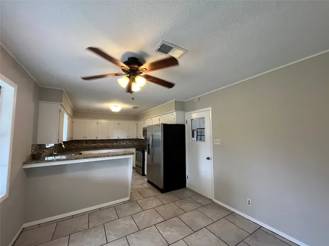 a kitchen with stainless steel appliances granite countertop cabinets and a refrigerator