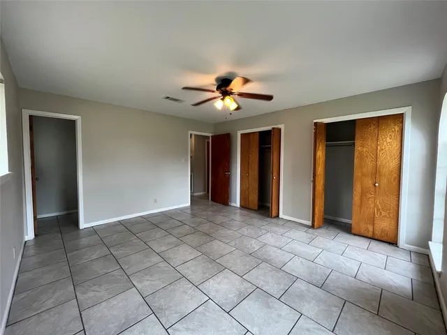 a view of an empty room with closet and a chandelier fan