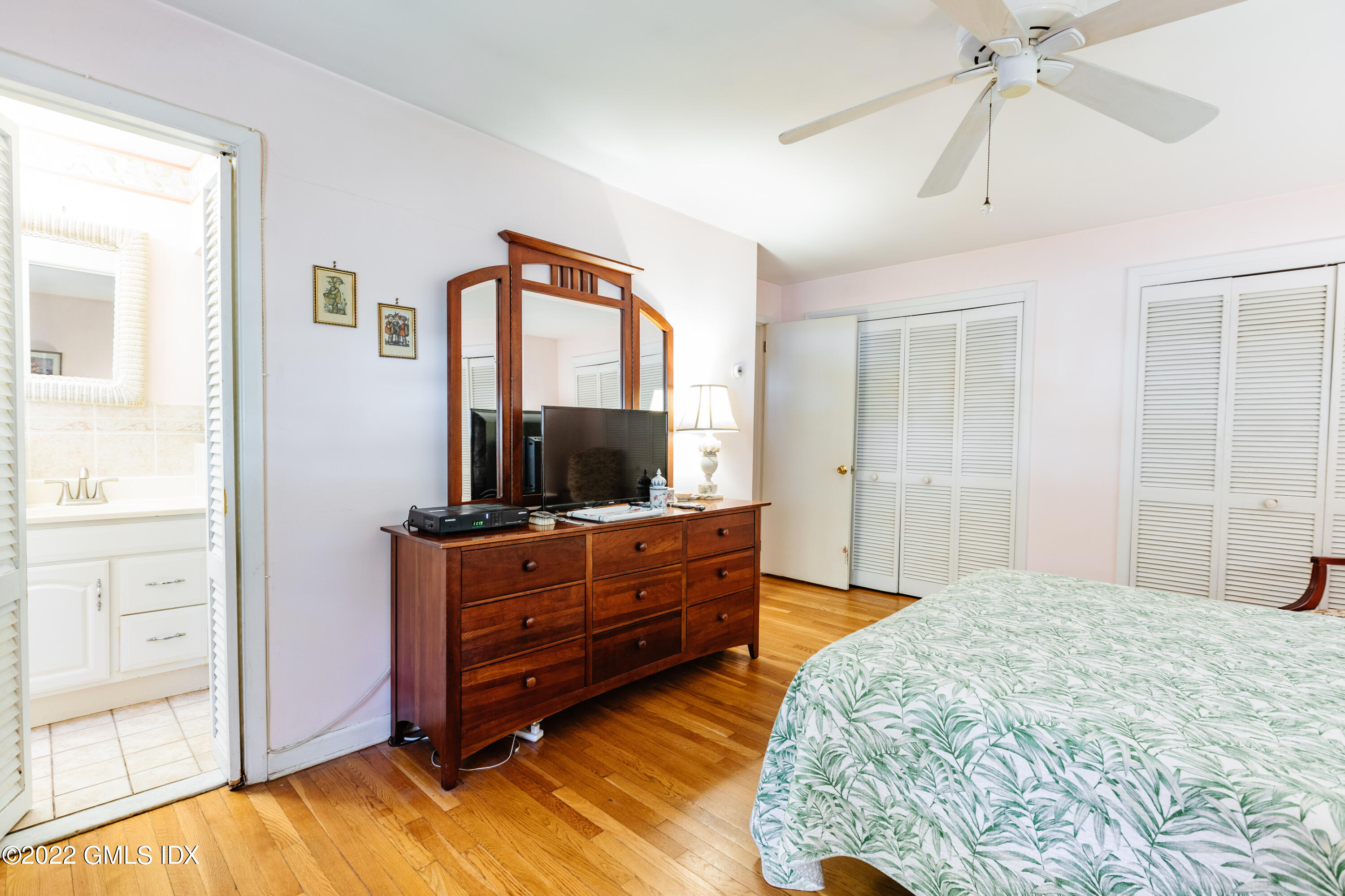 65 Laddins Rock Road Old Greenwich, CT 06870 - Photo 17 of 40 a bedroom with a bed and a flat tv screen on dresser