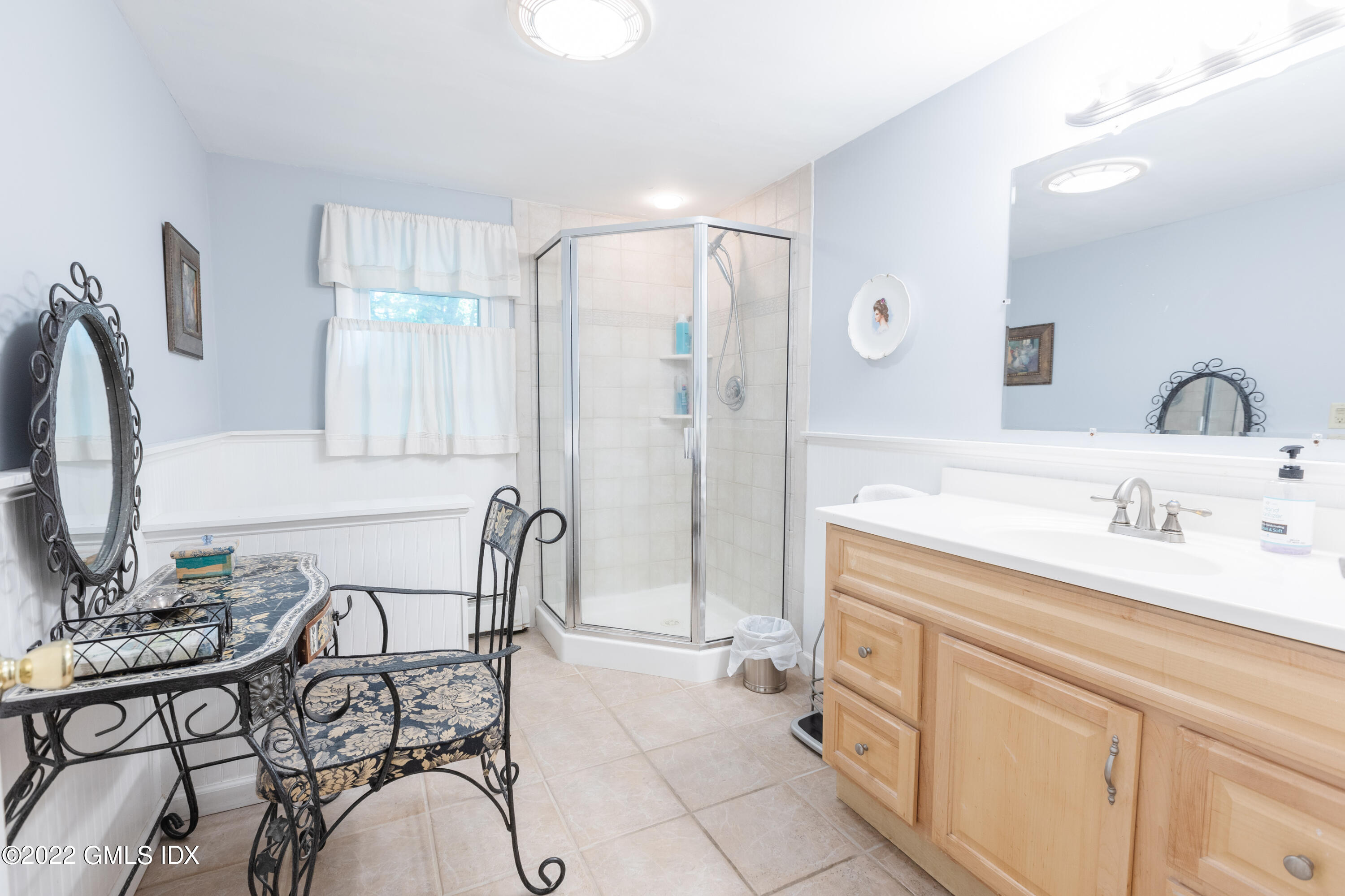 65 Laddins Rock Road Old Greenwich, CT 06870 - Photo 22 of 40 a spacious bathroom with a granite countertop sink a mirror and a shower