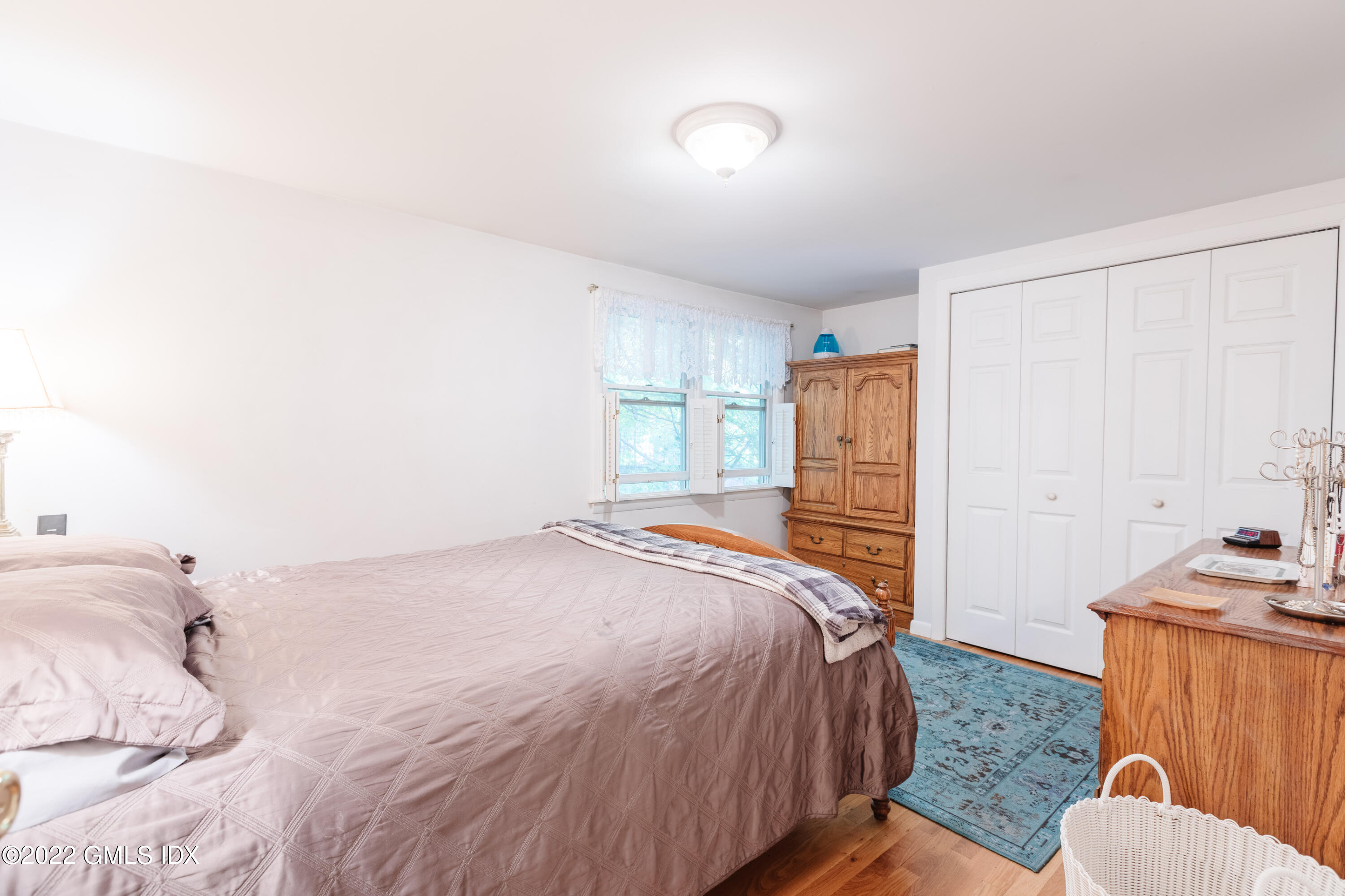 65 Laddins Rock Road Old Greenwich, CT 06870 - Photo 23 of 40 a bedroom with a bed and wooden floor