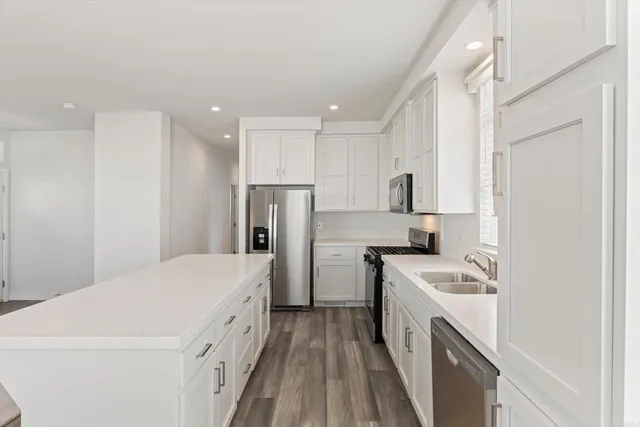a kitchen with a white stove refrigerator and cabinets