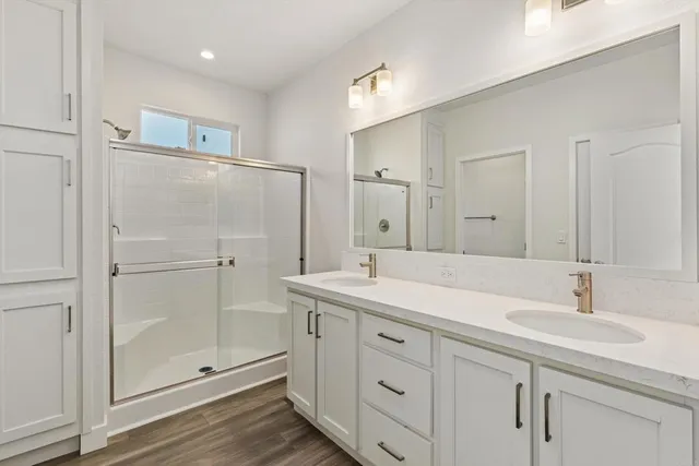 a bathroom with a shower sink and mirror