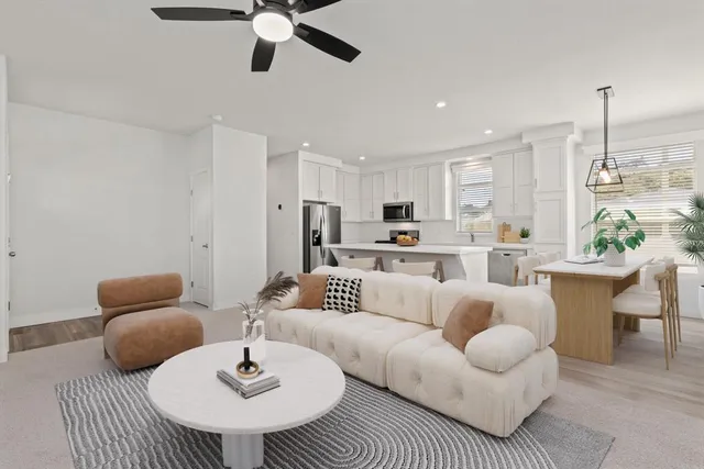 a living room with furniture kitchen view and a chandelier