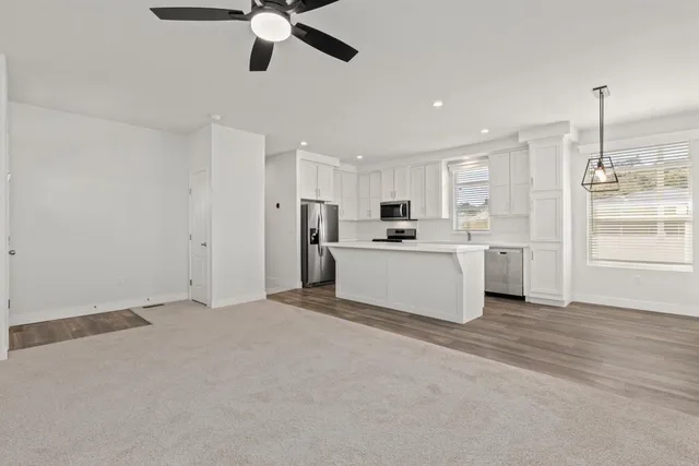a view of a kitchen with wooden floor and stainless steel appliances