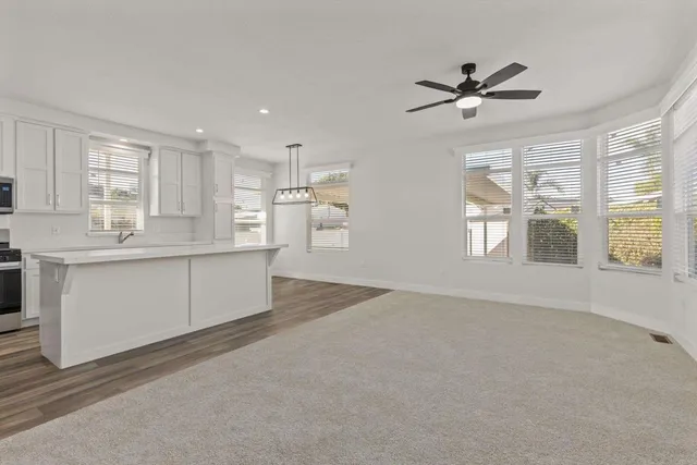 a view of kitchen with windows and ceiling fan