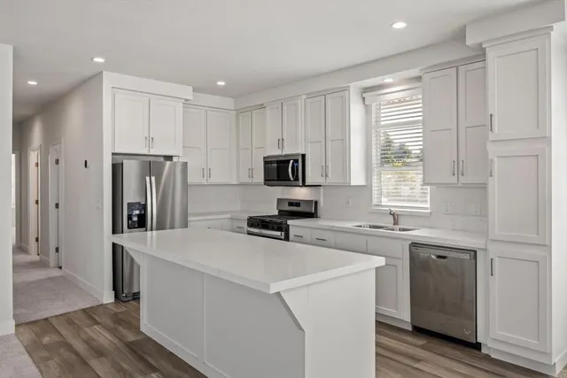 a kitchen with stainless steel appliances a refrigerator sink and microwave