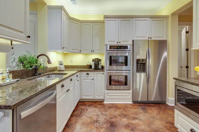a kitchen with granite countertop a refrigerator and a sink