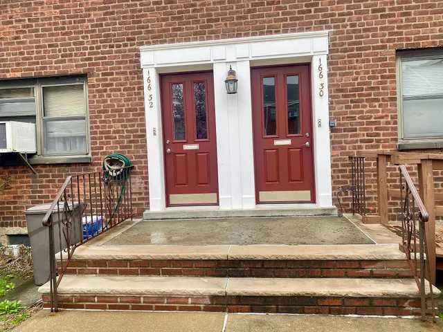 a view of a brick house with a bench in front of door