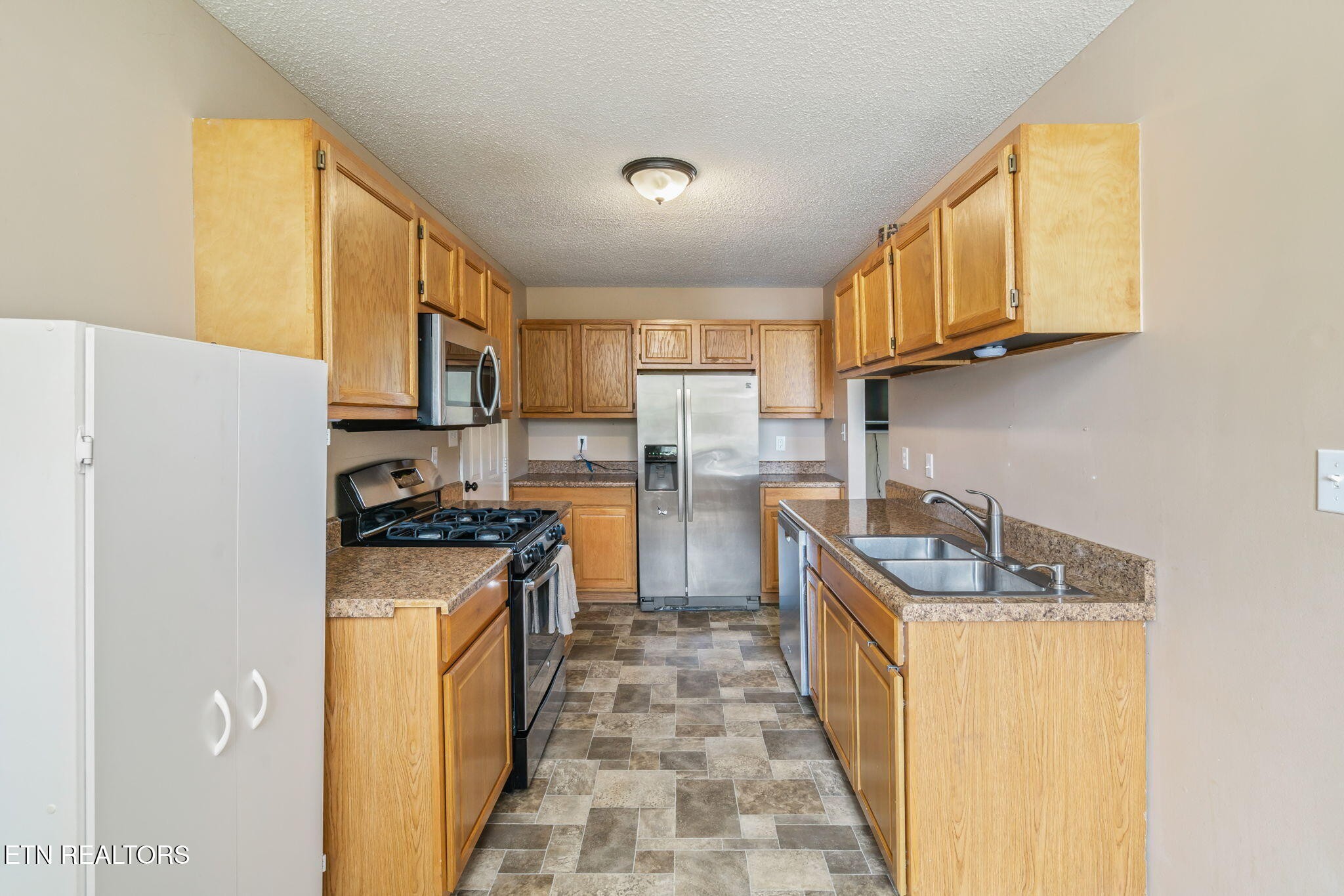 7536 Gary White Road Corryton, TN 37721 - Photo 11 of 26 a kitchen with stainless steel appliances granite countertop a stove a sink dishwasher and a refrigerator