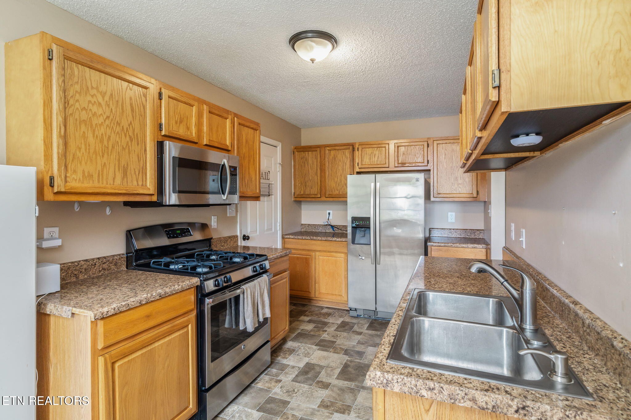 7536 Gary White Road Corryton, TN 37721 - Photo 12 of 26 a kitchen with granite countertop a sink a stove top oven and refrigerator