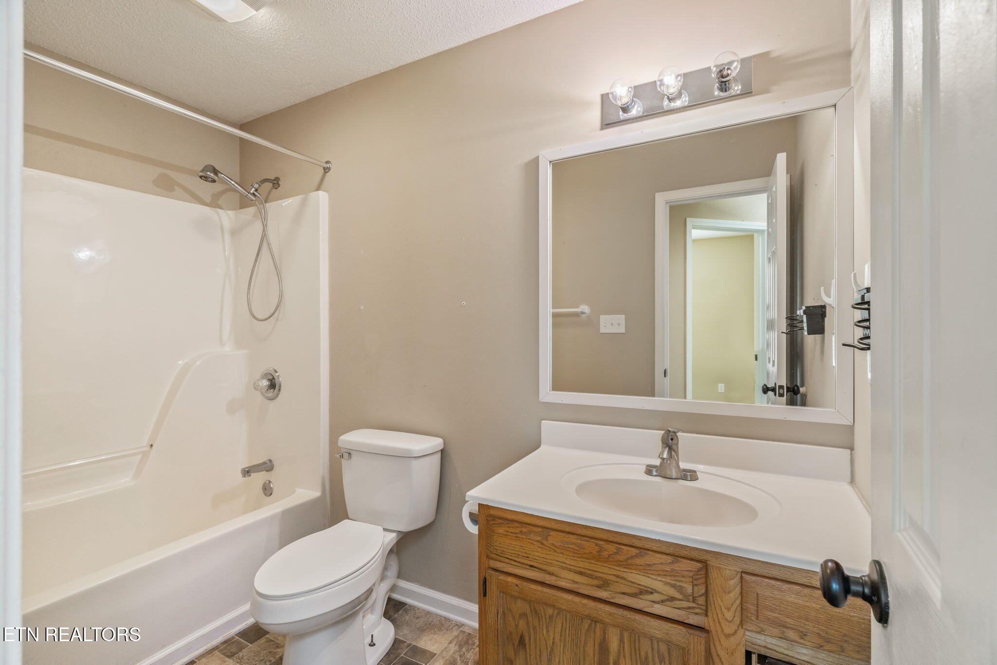 7536 Gary White Road Corryton, TN 37721 - Photo 22 of 26 a bathroom with a granite countertop sink toilet a mirror a vanity and shower