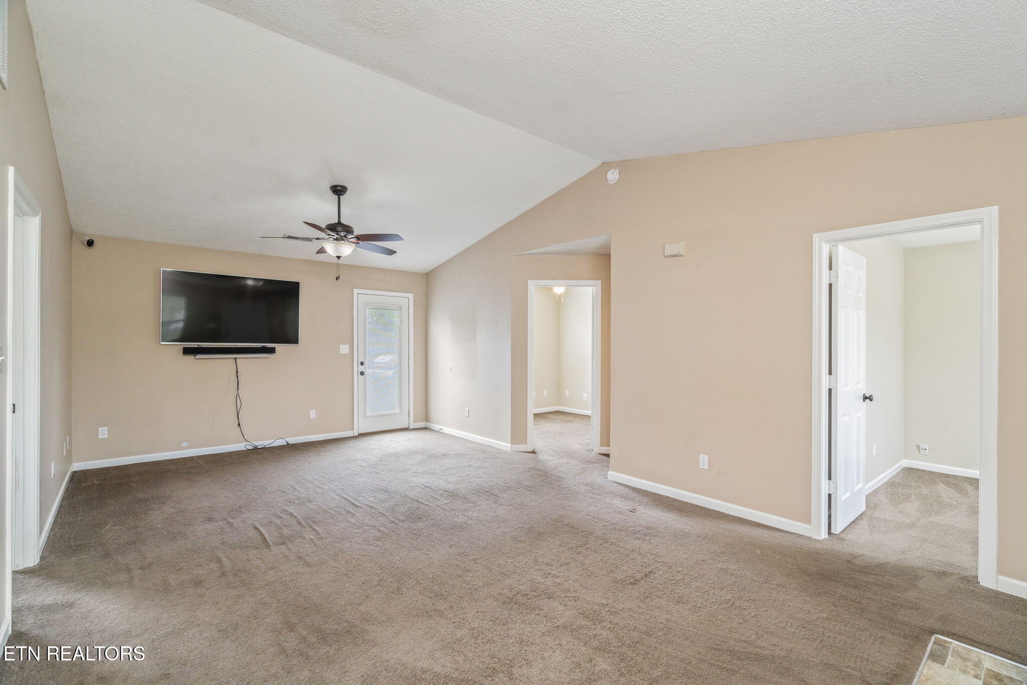7536 Gary White Road Corryton, TN 37721 - Photo 6 of 26 an empty room with a flat screen tv and a ceiling fan