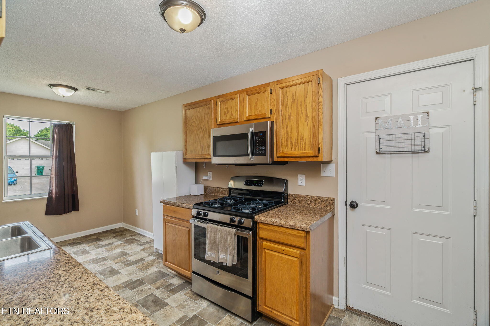 7536 Gary White Road Corryton, TN 37721 - Photo 8 of 26 a kitchen with stainless steel appliances granite countertop a stove a sink and a microwave