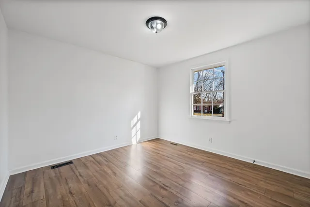 a view of a room with wooden floor and window