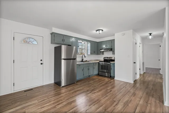 a kitchen with a refrigerator a sink and a stove top oven