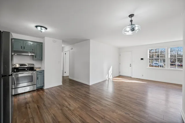 a view of a kitchen with a stove wooden cabinet and a refrigerator