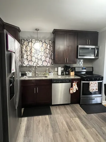 a kitchen with a refrigerator and a stove top oven