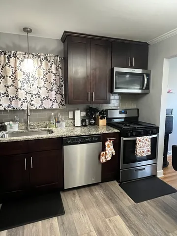 a kitchen with granite countertop a stove a sink and a microwave