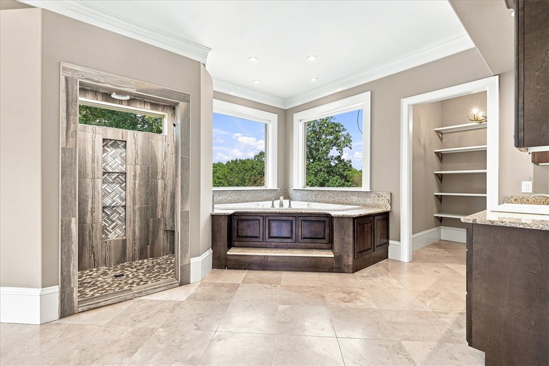 181 Sentell Road Williamston, SC 29697 - Photo 4 of 46 Primary bedroom elegant bathroom features a corner jetted tub with gorgeous views and a custom tiled walk-in shower.