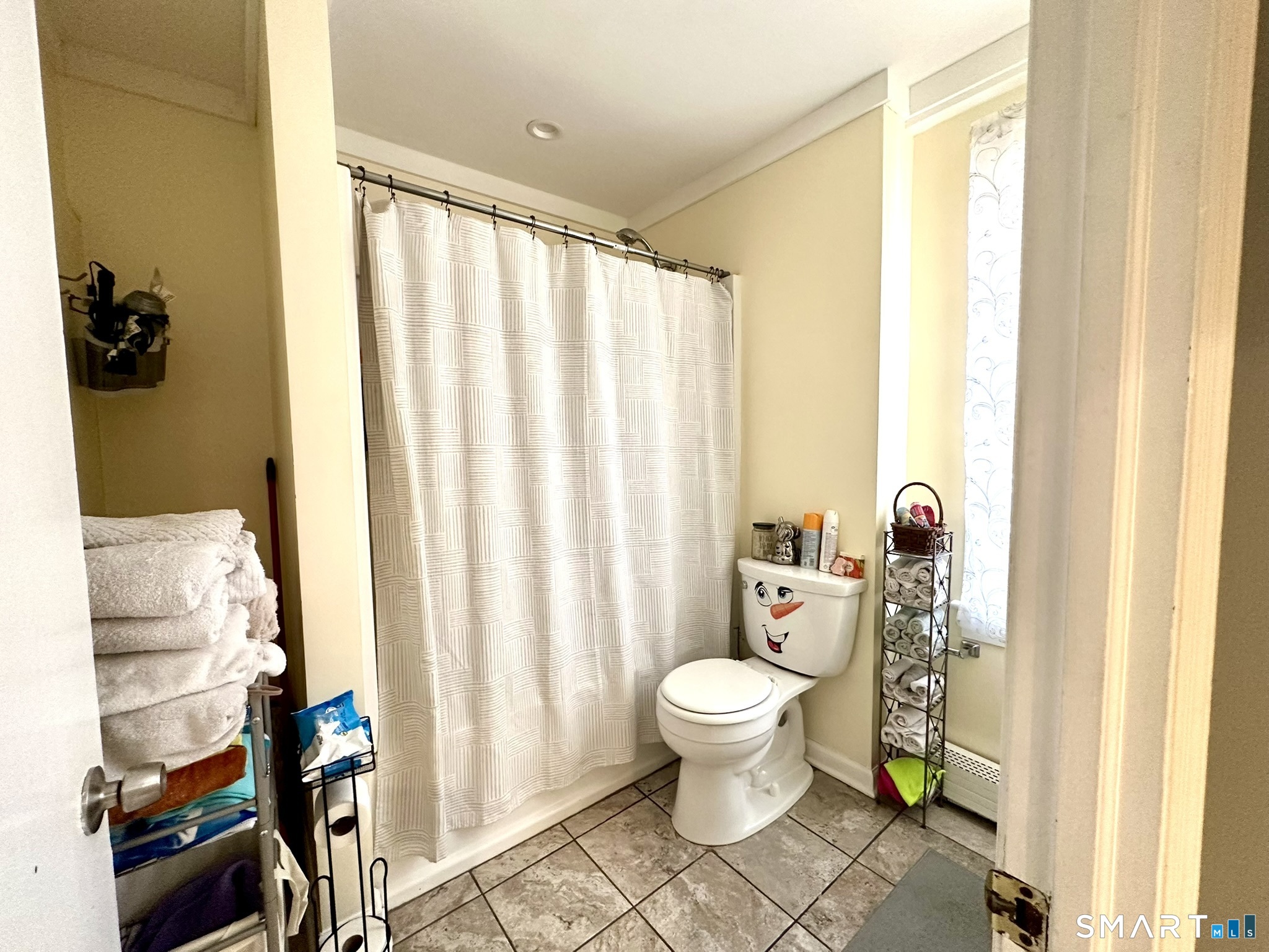 39 Pierce Street Fairfield, CT 06825 - Photo 8 of 18 a bathroom with a toilet and a shower curtain