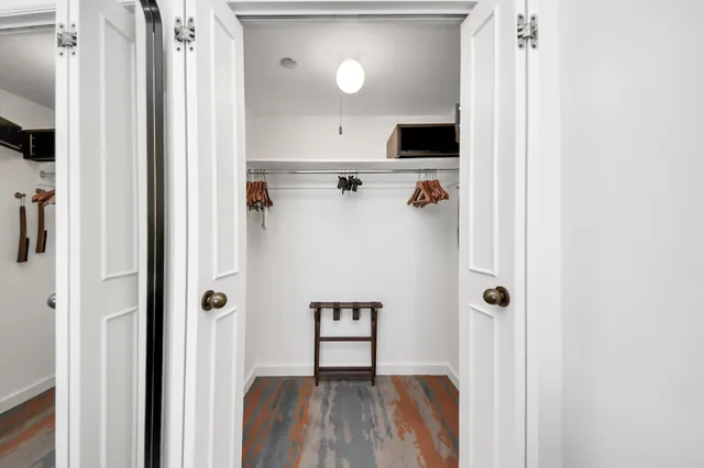 a spacious bedroom with a bed and a lamp on table