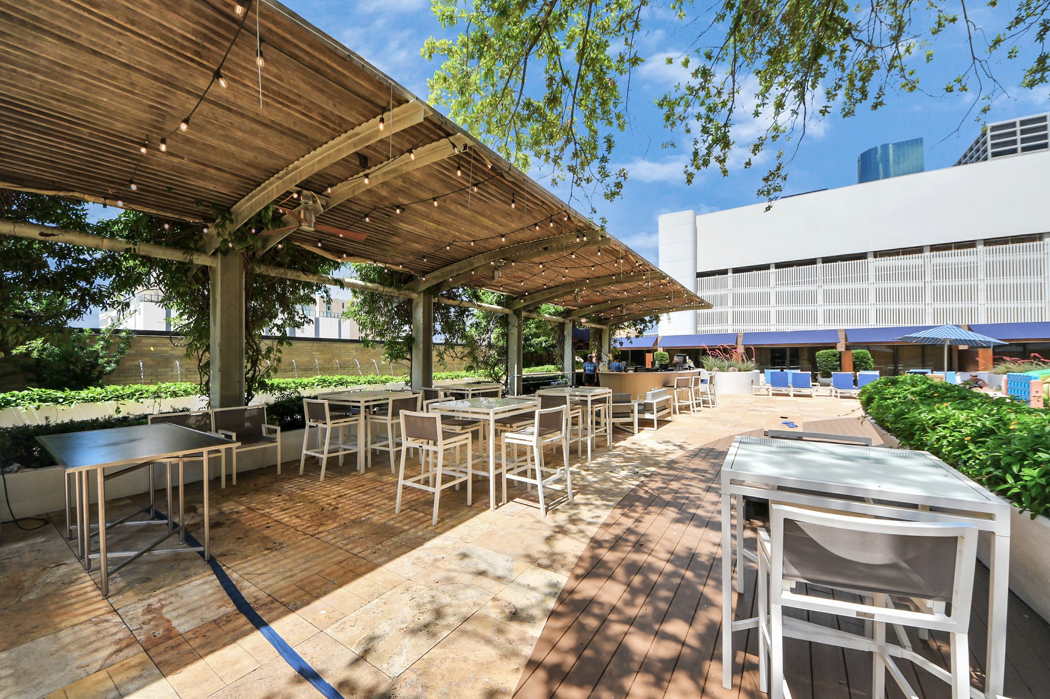 1300 Lamar Street, Unit T8 Houston, TX 77010 - Photo 44 of 48 a view of a patio with a table and chairs under an umbrella with a barbeque