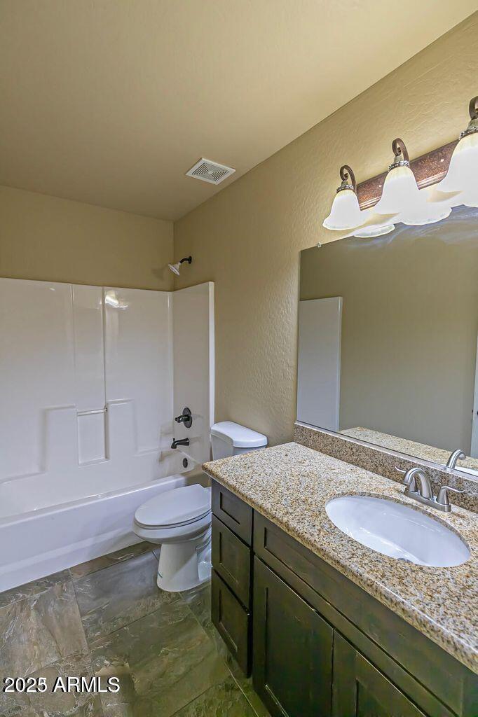 1161 East 5th Avenue, Unit 102 Mesa, AZ 85204 - Photo 6 of 9 a bathroom with a granite countertop sink a toilet and a mirror