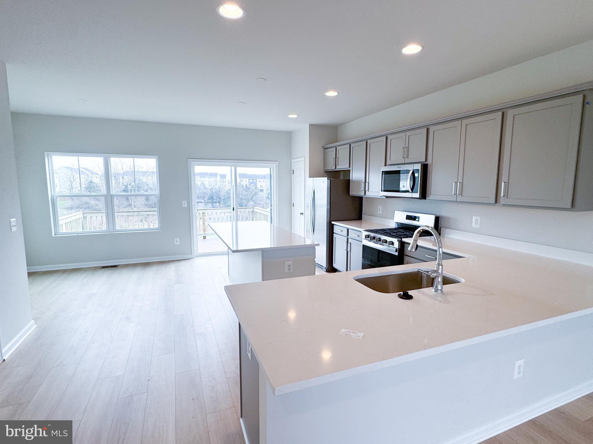 116 Flaxen Mane Court Stephenson, VA 22656 - Photo 7 of 28 a kitchen with a sink a stove a microwave and cabinets