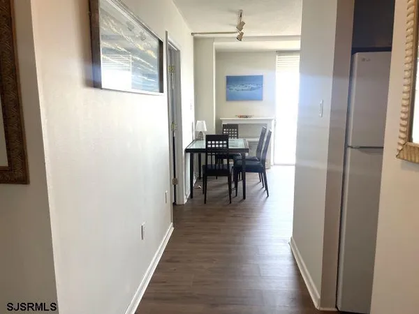 a view of a hallway with wooden floor a fireplace and a window