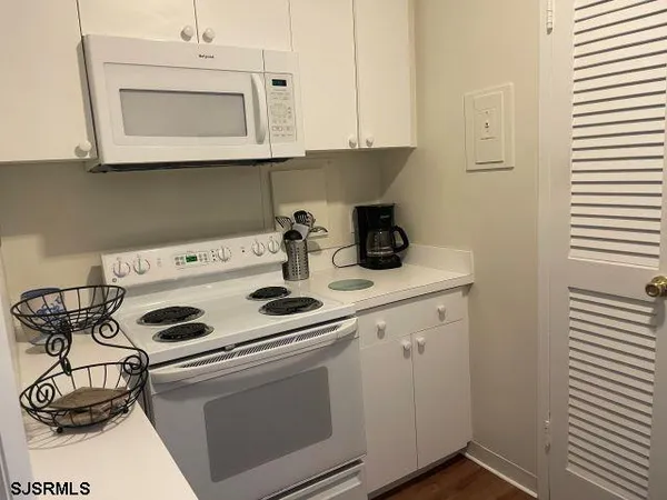 a kitchen with a stove and white cabinets