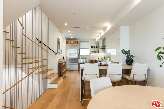 a living room with couches a coffee table and a dining table with wooden floor