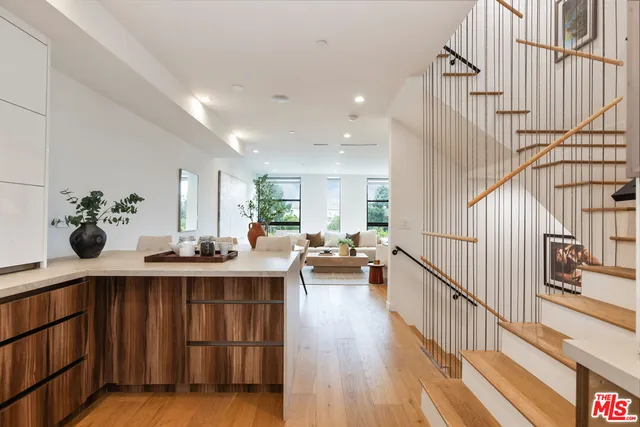 a view of a hallway with wooden floor and furniture