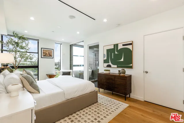 a bedroom with a large bed and a chandelier