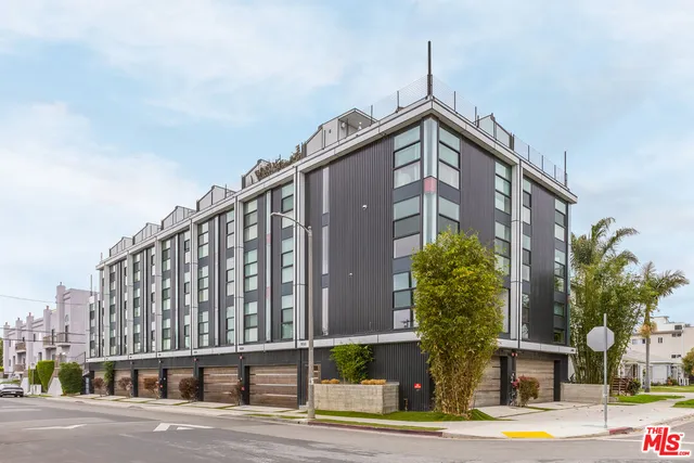 a view of a tall building next to a yard